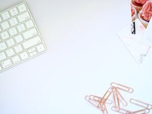 Clean and organized workspace featuring a keyboard and rose gold paper clips, perfect for design inspiration.